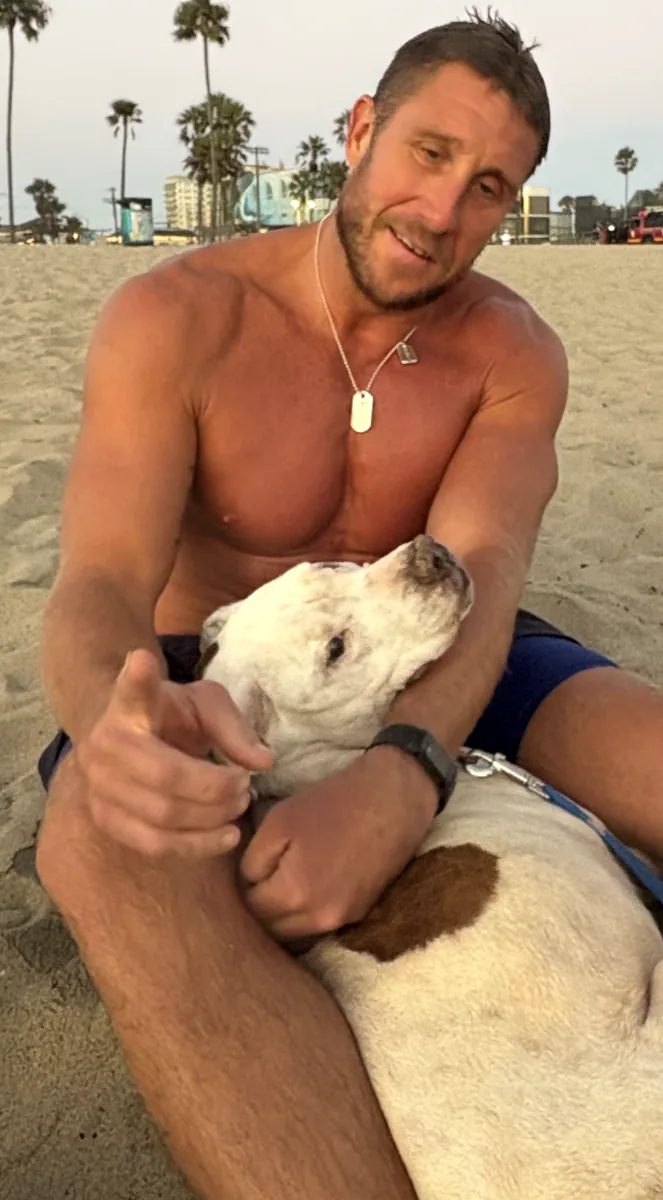 Garrett Hess with his dog Ruca on the beach